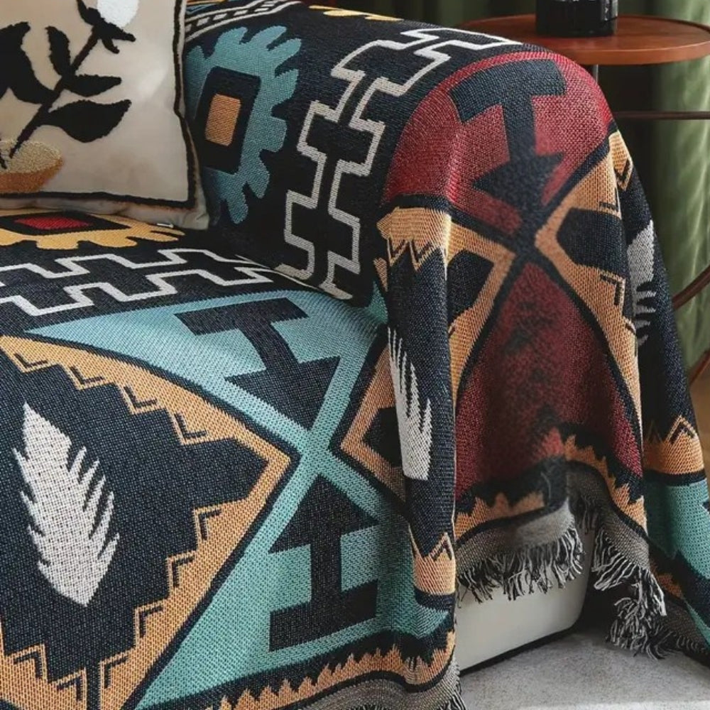 Copridivano boho con motivo geometrico azteco e nappine